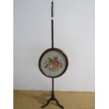 A 19th century mahogany pole screen with needlepoint insert