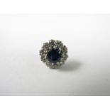 A single diamond and sapphire stud earring, in a flower head cluster arrangement, the central