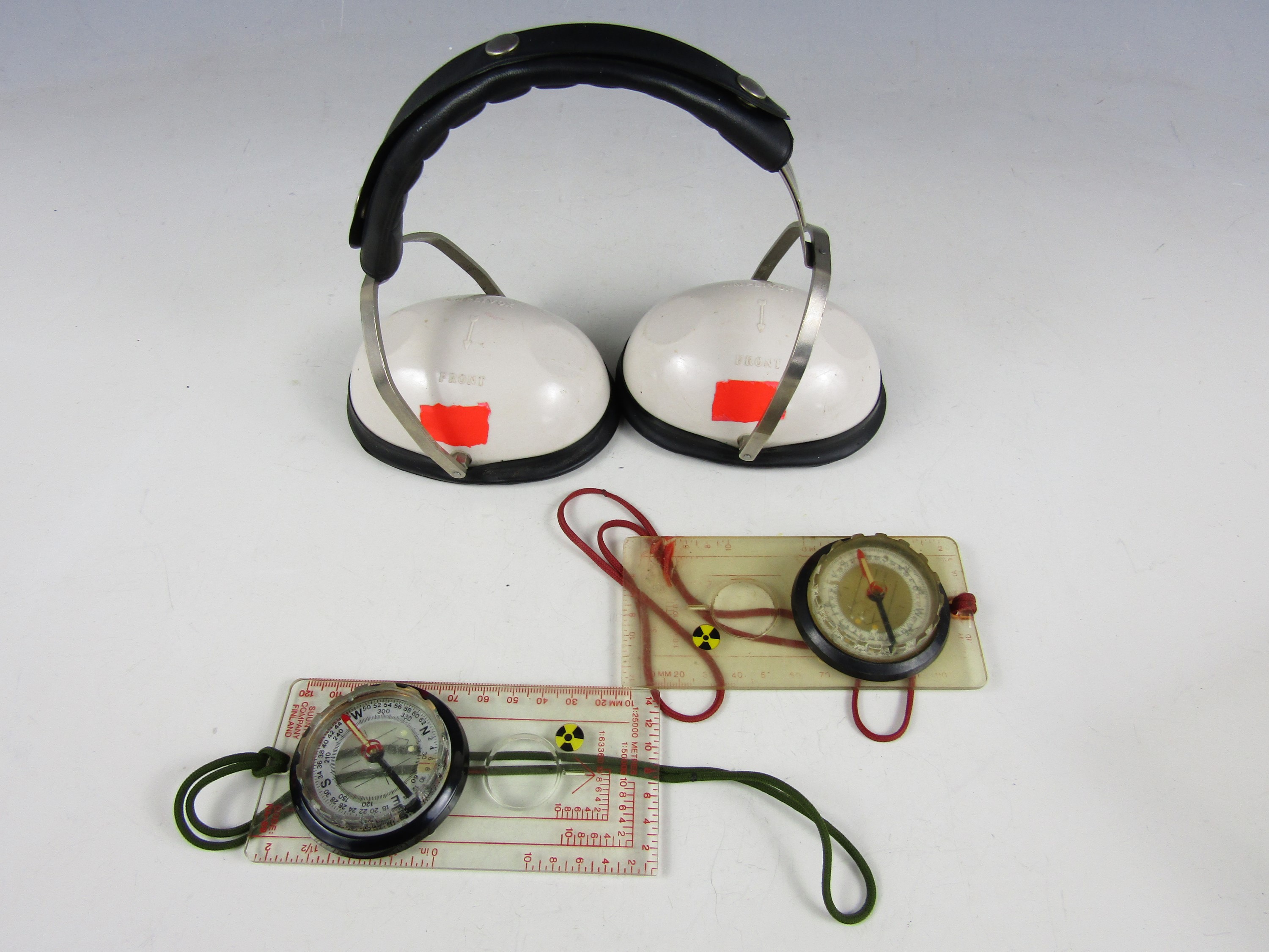 Two Suunto of Finland RA-69 orienteering compasses and a pair of Amplivox ear protectors