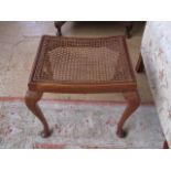 A mahogany stool with caned seat