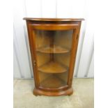 A contemporary mahogany freestanding corner cabinet