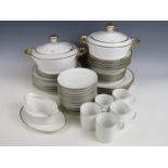 A vintage white and gold porcelain dinner service including tureens and plates etc.