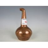 A copper paperweight modelled as a whisky still