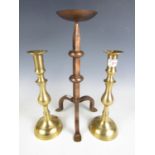 A pair of brass candlesticks together with one other large pricket candlestick