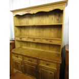 A contemporary pine kitchen dresser measuring, 152 x 200 x 49 cm