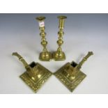 A pair of cast brass chambersticks together with a pair of brass candlesticks