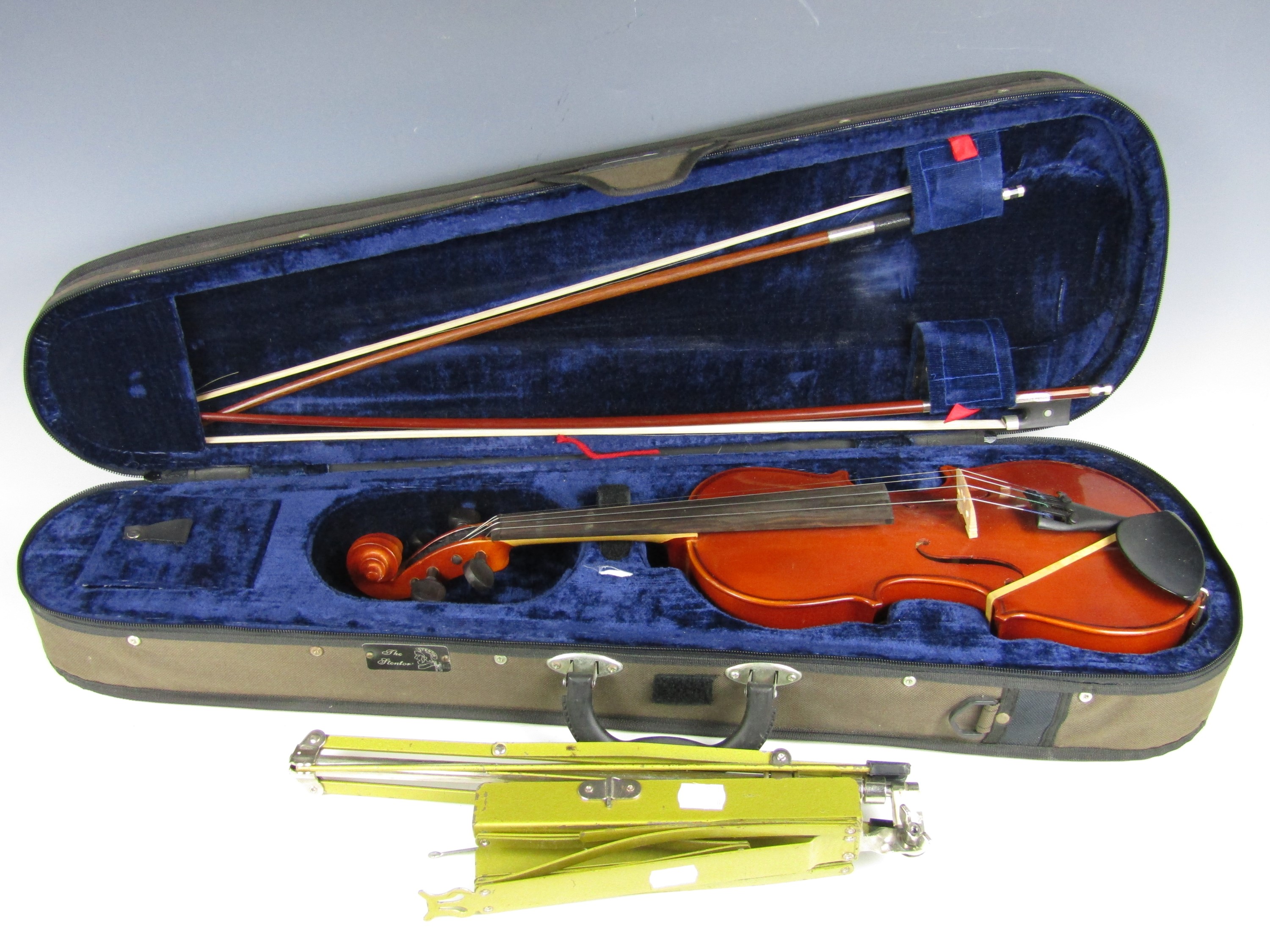 A cased Stentor Student II violin together with two contemporary bows and a music stand