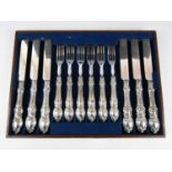 A set of six Victorian silver handled dessert knives and forks, each moulded in a scrolling