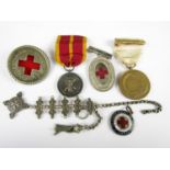 A group of Red Cross and similar medals and insignia including a silver watch chain and a London