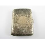 A George V silver cigarette case, of cushion form, engraved with scrolling foliage surrounding a