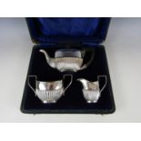 A cased George V silver bachelor's tea set, of Georgian shape with half gadrooned decoration, Wilmot