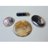 Four late 19th / early 20th Century white metal mounted polished agate brooches, test as silver