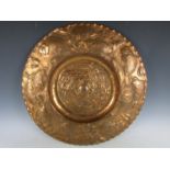 A large Arts and Crafts copper tray in the manor of Newlyn, of circular shape with repousse