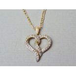 A contemporary diamond and yellow-metal pedant in the form of an interlocking ribboned heart, the