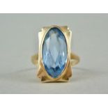 A blue topaz cocktail ring, with lenticular cut stone of approximately 1.7 x 0.8 cm, rub set