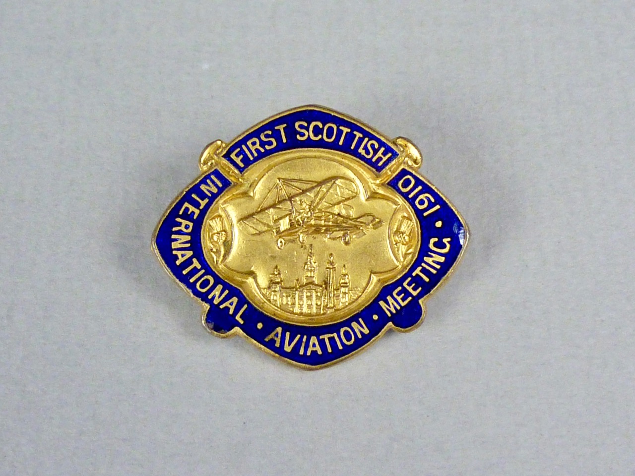 A 1910 First Scottish International Aviation Meeting enamelled lapel badge