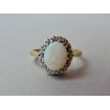 An opal and diamond dress ring, with claw set cabochon of approximately 1.10ct, claw set within an