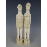 A pair of early 20th Century African carved ivory figures, respectively of a stylized native man and