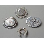 Four Victorian silver brooches, one in the form of a horseshoe with yellow-metal garland, two with