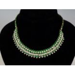 An impressive diamond and emerald collar, the necklace in a tiered arrangement comprising