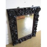 A late 19th Century large and elaborately carved wall mirror, 92 cm x 75 cm