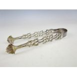 A pair of silver sugar tongs, the arms cast in a reticulated pattern with shell-form terminals,