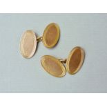 A gentleman's pair of 9ct gold cufflinks, of oval shape with an engine turned border, 7.3g