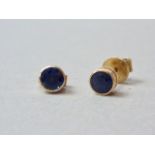 A pair of sapphire stud earrings, the stones each of approximately .34ct, bezel set in yellow-metal,