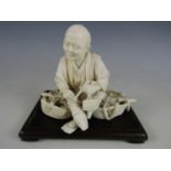 A Meiji Japanese single-piece ivory okimono carved in depiction of an elderly man, sat atop his yoke