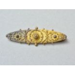 A Victorian high carat yellow metal bar brooch, of cannetille decorated and pelleted lenticular