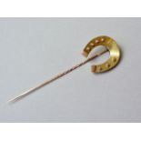 A Victorian yellow-metal stick pin, the terminal modelled in the form of a horseshoe, tests as gold,