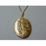 A large 9ct gold oval pendant locket, the face bright-cut engraved with a floral sprig, 4.5 cm