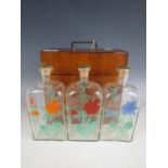 A 19th Century mahogany cased set of three free-blown and hand enamelled glass decanters