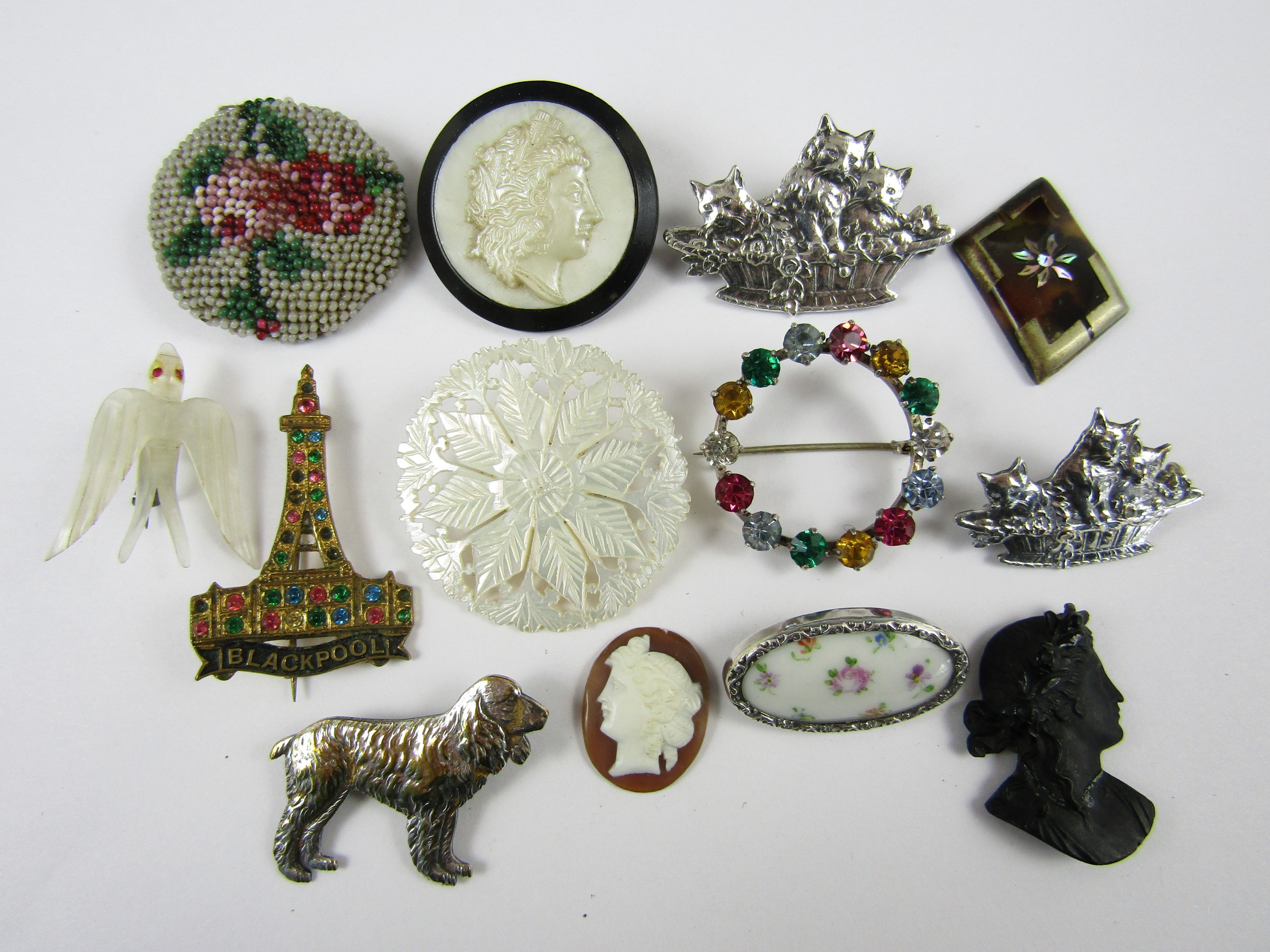 Vintage costume jewellery including a carved mother of pearl brooch, and white metal novelty