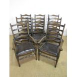 A set of older reproduction oak ladderback chairs with drop in brown hide upholstered seats,