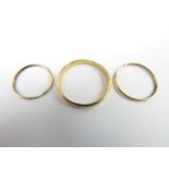 A pair of yellow metal hoop earrings, stamped 9ct, test as gold, and a yellow-metal wedding band