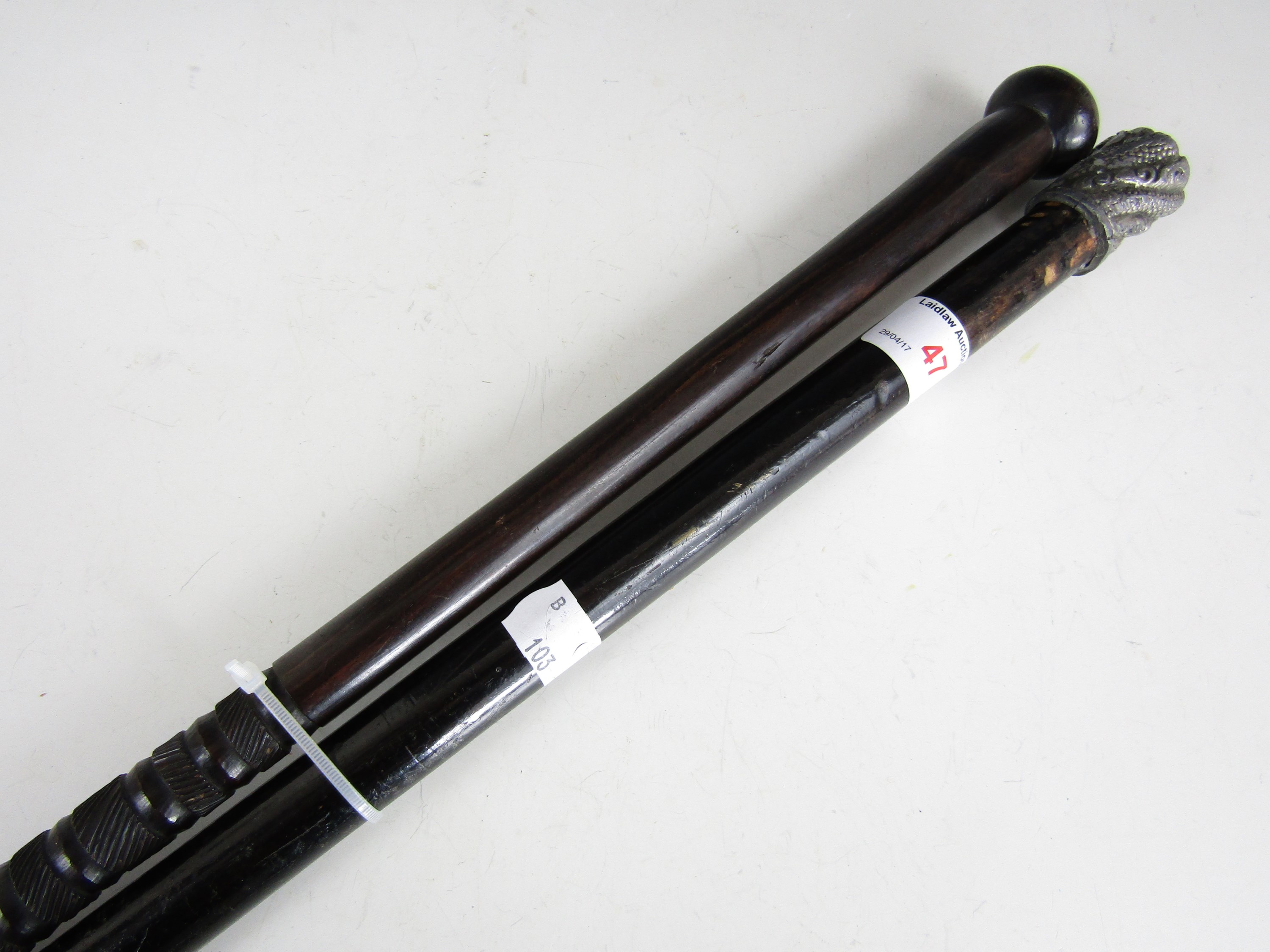 A metal mounted walking cane together with one other similar