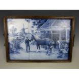 An early 20th Century blue and white tiled oak tea tray depicting a farrier at work