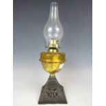A 19th Century oil lamp with amber glass reservoir and cast base