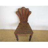 A Victorian carved oak shell back hall chair