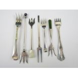 A selection of eight sterling silver cocktail forks, some having mother of pearl and other finials