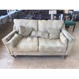 A contemporary gold chenille striped two seater sofa