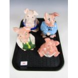 A collection of four savings bank pig figurines