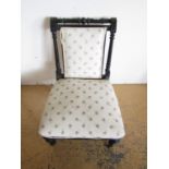 A Victorian ebonised nursing chair with brass castors (a/f)