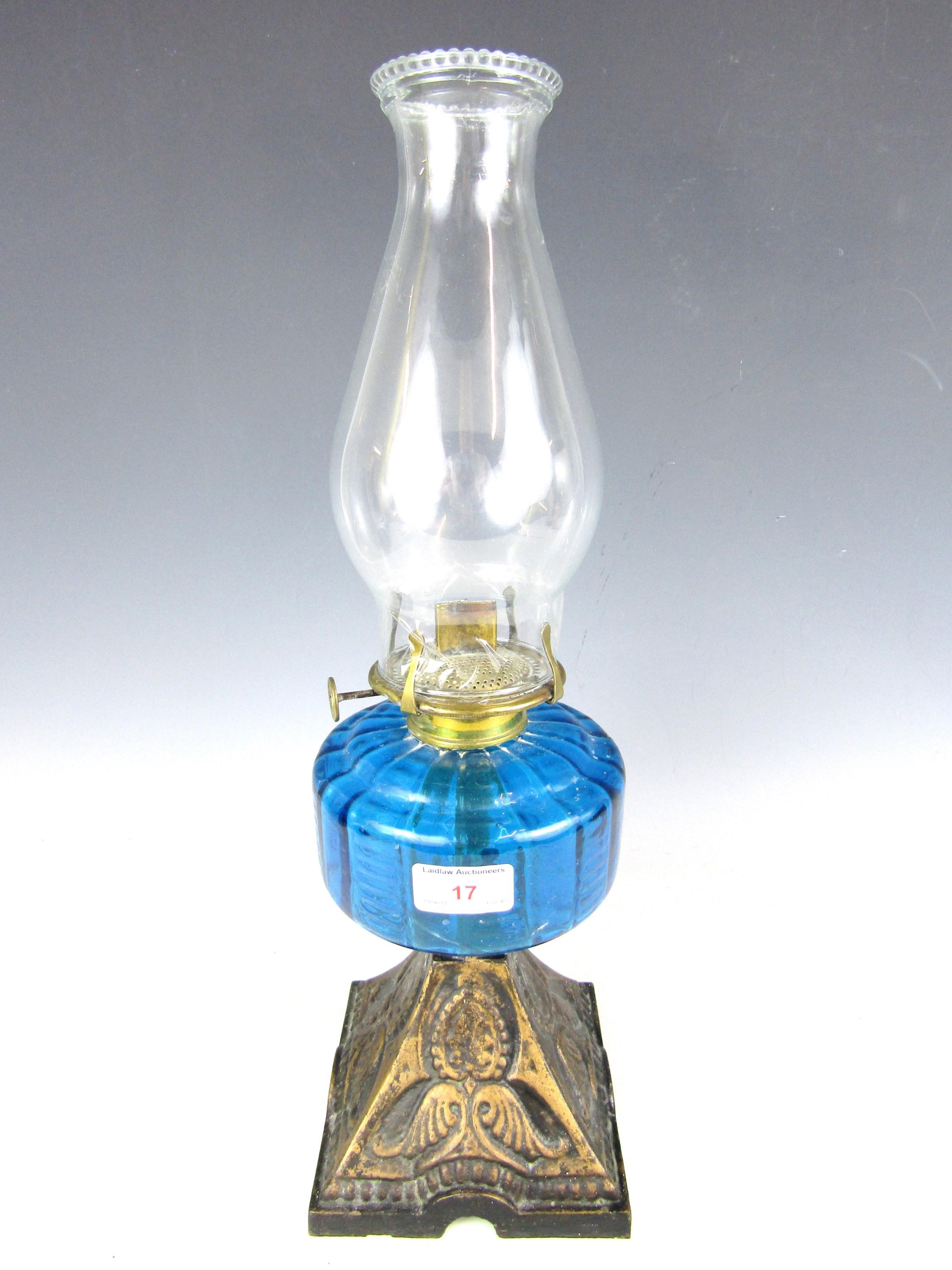 A Victorian oil lamp with blue glass reservoir and cast base