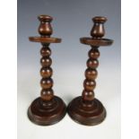 A pair of George V turned oak knopped candlesticks