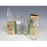 Two vintage milk bottles together with two baby glass feeding bottles in their original cartons