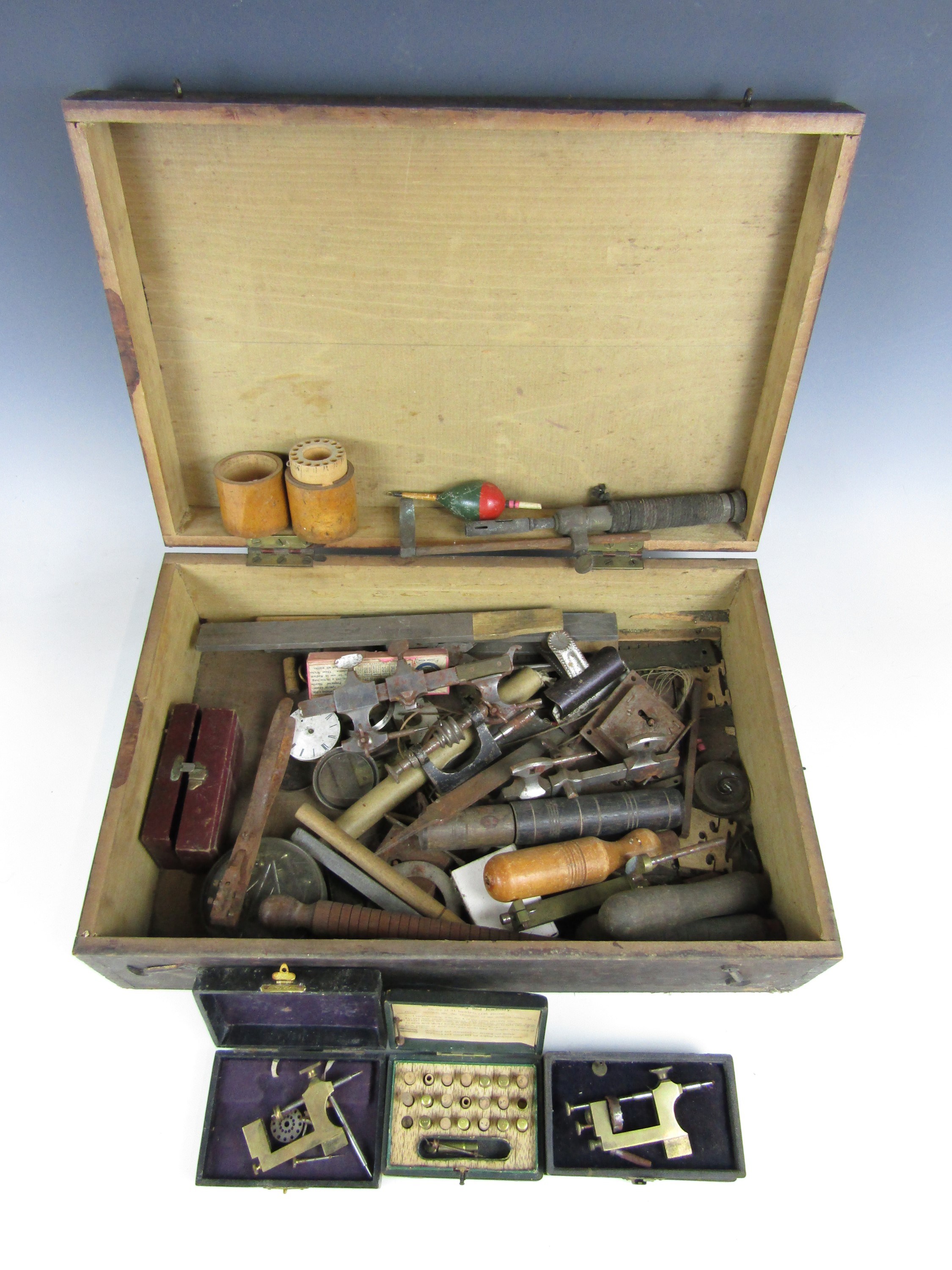 A wooden box containing vintage watchmakers' tools etc.