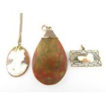 An early 20th Century 9ct gold mounted celluloid pendant, together with a rolled gold pendant and