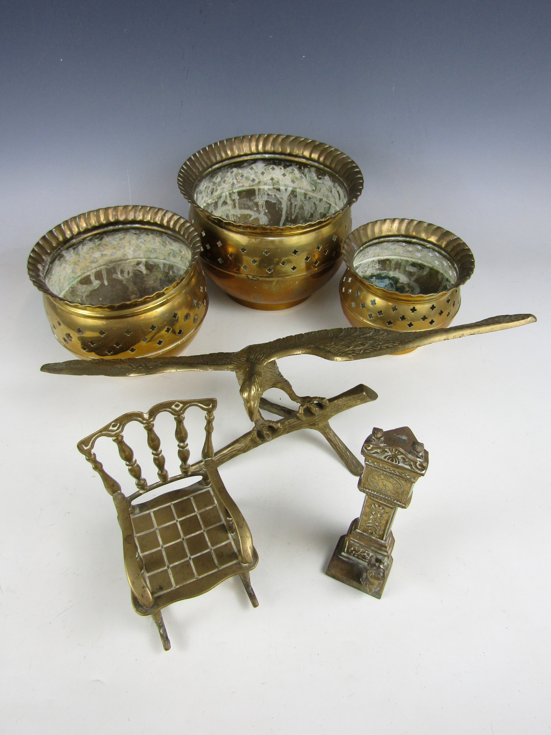Vintage brassware including three graded cachepots, a brass model of an eagle, and a novelty brass